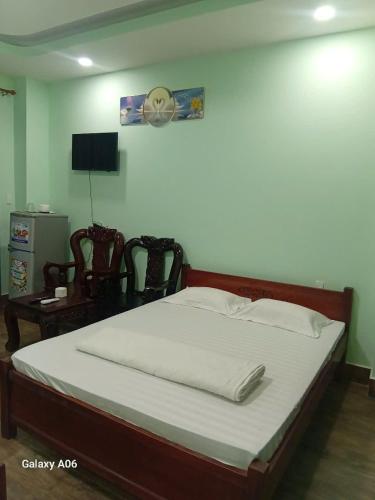 a large bed in a room with a table at HOTEL MOTeL Đồng Khởi in Giồng Tú Ðiền