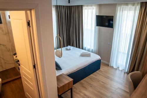 a small bedroom with a bed and a room with windows at Volotel SkyWay in Cluj-Napoca