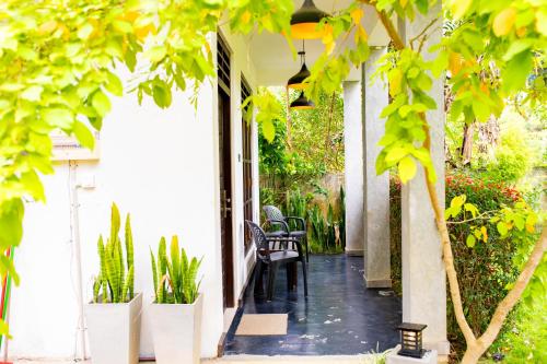 a porch of a house with chairs and plants at Traveller's Villa in Hatton