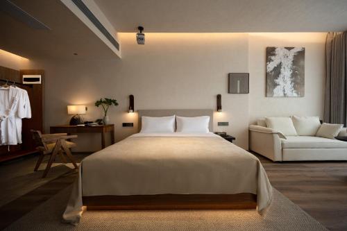 a bedroom with a large bed and a couch at 大有观于All about Yu Hotel in Chongqing