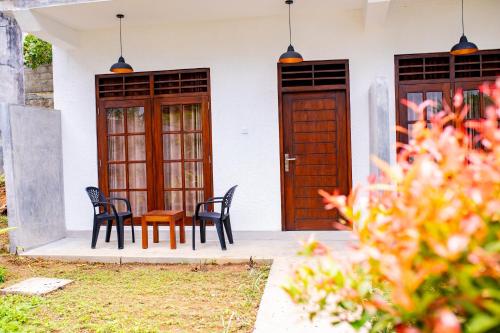 two chairs and a table in front of a house at Traveller's Villa in Hatton