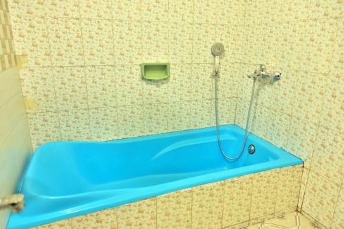 e bagno con doccia e vasca blu. di Nila Heavens - Spacious 5 BHK Homestay , ideal for families a Guruvayoor