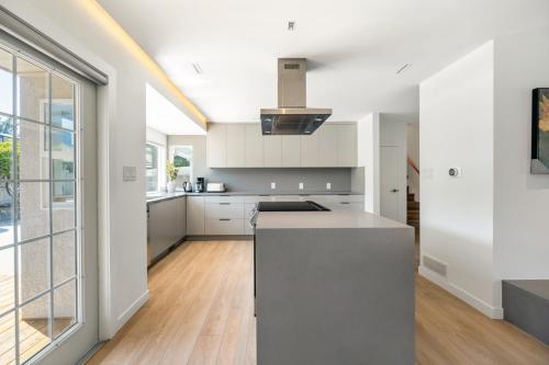 a kitchen with white cabinets and a stove top oven at Luxury&Brand-new 3BD 2BTH House in Burnaby