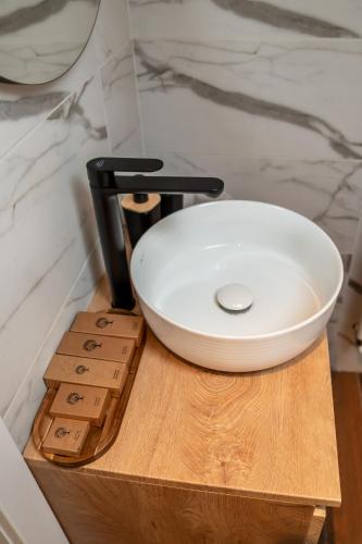 a white bowl on top of a wooden table at Volotel SkyWay in Cluj-Napoca