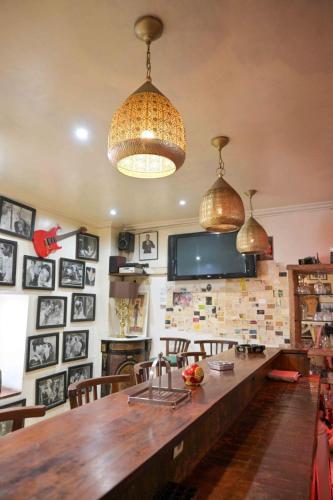 a kitchen with a large wooden table and pendant lights at Hotel Brajas in Antananarivo