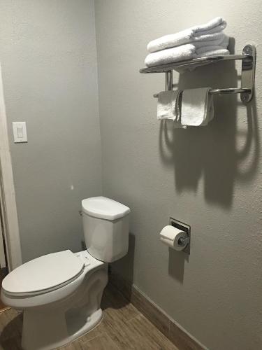 a bathroom with a white toilet and some towels at Town House Motel in Lynwood