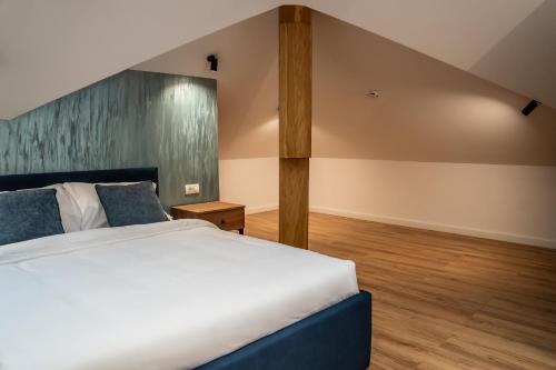 a bedroom with a large bed and wooden floors at Volotel SkyWay in Cluj-Napoca