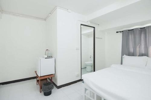 a white bedroom with a bed and a mirror at GO Inn Rama 3 BKK - โกอินน์ พระราม 3 in Bang Khlo