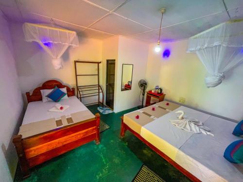 a bedroom with two beds and a tub in it at Sigiriya Luminary Homestay in Sigiriya
