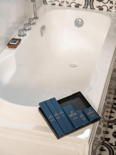 two books sitting on top of a bath tub at The Odys Boutique Hotel in Ho Chi Minh City