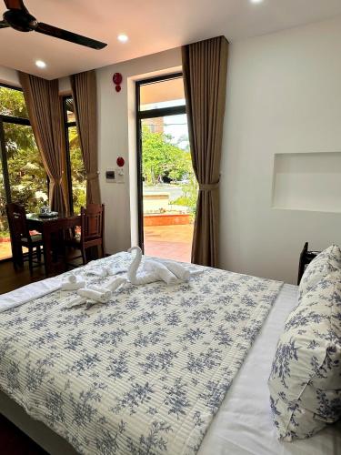 a bedroom with a bed with a blue and white comforter at The Mango Villas in Hoi An