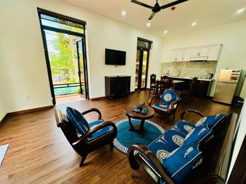 a living room with a couch and chairs and a table at The Mango Villas in Hoi An