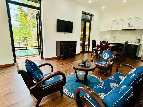 a living room with a couch and chairs and a table at The Mango Villas in Hoi An
