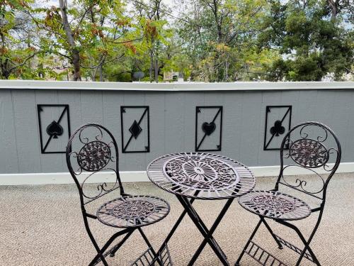 two chairs and a table in front of a fence at Studio with balcony in Albuquerque
