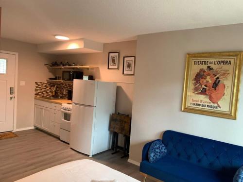 a kitchen with a blue couch and a white refrigerator at Studio with balcony in Albuquerque