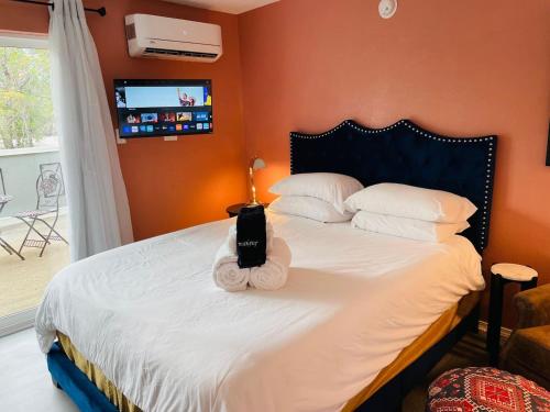 a bedroom with a white bed with a television on the wall at Studio with balcony in Albuquerque