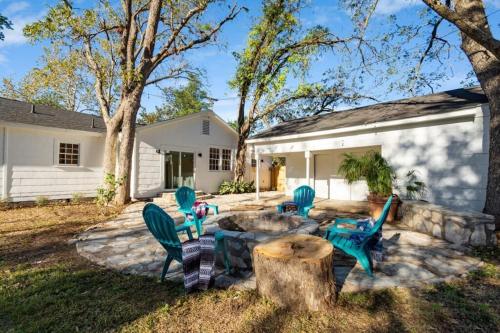 a backyard with chairs and a table and a tree stump at Luxury Bungalow Near Main W Hot-tub And Firepit in Fredericksburg