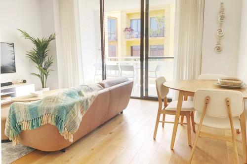 a living room with a couch and a table at Pearl on Pakenham- Modern & Central w king beds in Fremantle