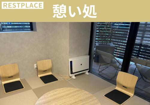 a room with two chairs and a tv and a table at スゴイサウナ アンド ステイ 麻布十番駅前 男性専用 in Tokyo