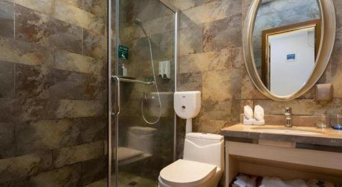 a bathroom with a shower and a toilet and a sink at Leisurely Hotel Shenzhen in Shenzhen