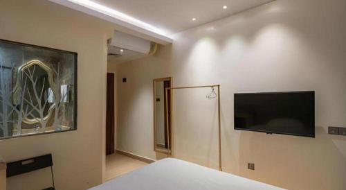 a bedroom with a bed and a flat screen tv at Leisurely Hotel Shenzhen in Shenzhen