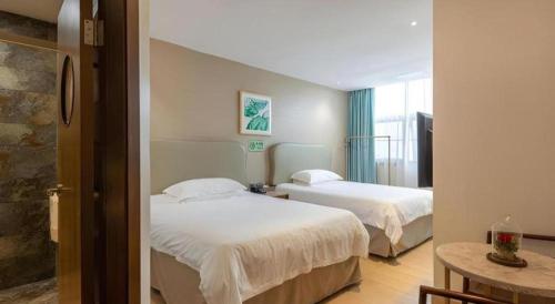 a hotel room with two beds and a window at Leisurely Hotel Shenzhen in Shenzhen