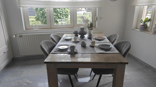 a dining room with a wooden table and chairs at holiday home Zonnestraal in Zonhoven