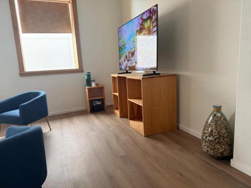 a living room with a flat screen tv on a wooden stand at Unicorn Zebra in Tucson