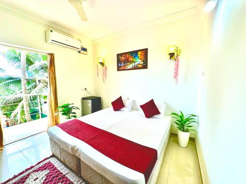 a bedroom with a bed with a red blanket at Hotel El - Paso in Arambol