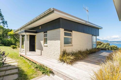 a small house with a wooden deck in front of it at Breathtaking views of Lake Taupo in Taupo