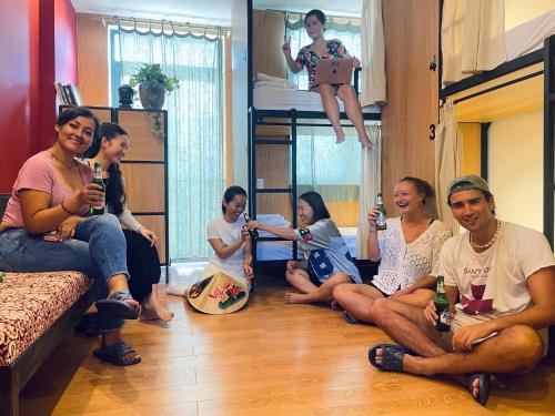 a group of people sitting on the floor drinking beer at Dom Hostel Old Town Hoi An in Hoi An