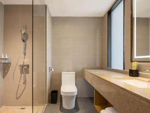 a bathroom with a toilet and a glass shower at City Comfort Inn Shiyan Wudang Mountain in Danjiangkou