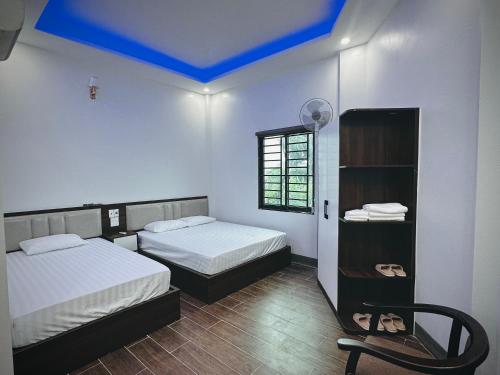 a bedroom with two beds and a blue ceiling at Nhà Nghỉ Tân Tiến in Hà Lộc