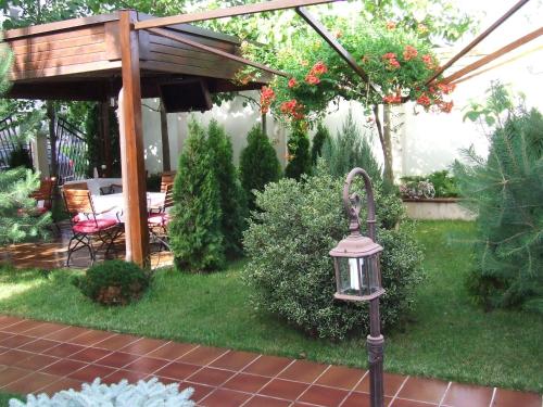 a garden with a lantern and a pergola at Hotel Senator in Slatina