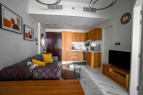 a living room with a couch and a tv and a kitchen at Canal View 1BR near Galleria Mall & Cleveland in Abu Dhabi