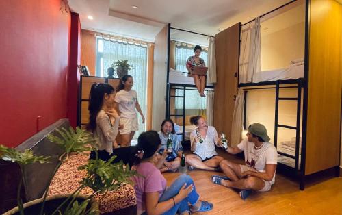 a group of people sitting in a room with bunk beds at Hoi An Ancient Town Hostel & Bar in Hoi An