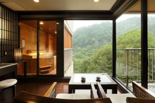 a room with a table and a large window at Tsuganoki in Nikko