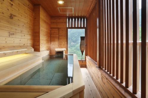uma sauna com piso de vidro num edifício de madeira em Tsuganoki em Nikko