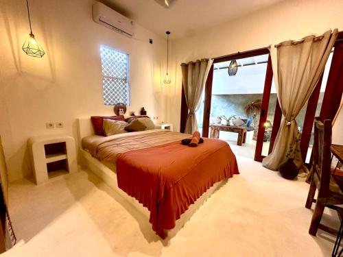 Un dormitorio con una cama grande con una manta roja. en Pondok Dembe, en Uluwatu