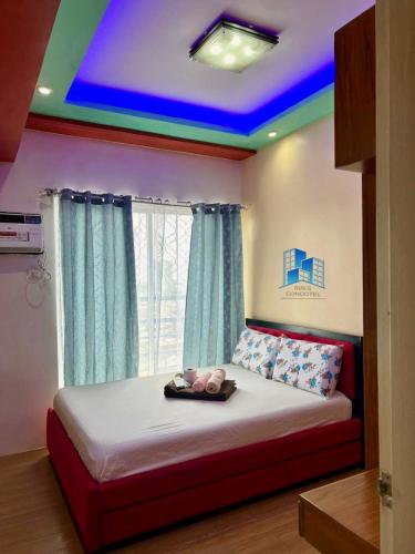 a bedroom with a bed with a blue ceiling at Studio and 1 Bedroom Unit at Riri's Condotel, The Loop Tower in Cagayan de Oro