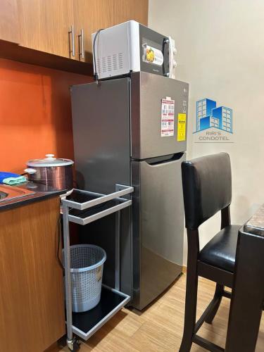 a refrigerator with a microwave on top of it in a kitchen at Studio and 1 Bedroom Unit at Riri's Condotel, The Loop Tower in Cagayan de Oro