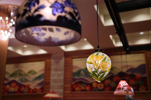 a chandelier with a flowery light hanging from a ceiling at Tsuganoki in Nikko