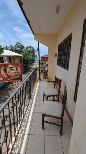 two chairs sitting on the balcony of a building at Apartamento Coco & Tambor in Livingston Izabal in Lívingston