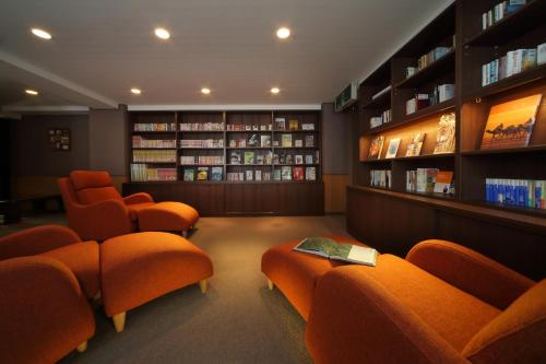 a library with orange chairs and books at Tsuganoki in Nikko