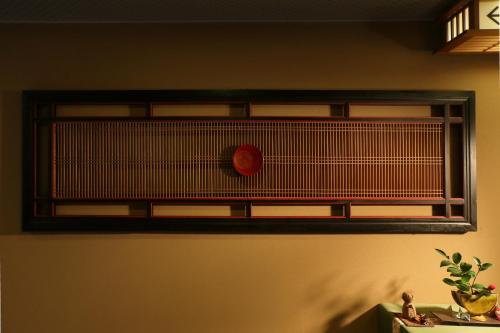 a shelf on a wall with a red clock on it at Tsuganoki in Nikko