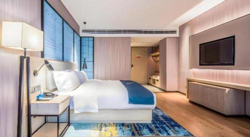 Postel nebo postele na pokoji v ubytování Echarm Hotel Torch Development Zone Zhongshan Station