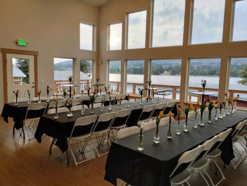 a large room with long tables and chairs with flowers on them at Fireweed Cabin - Homer Seaplane Base in Homer