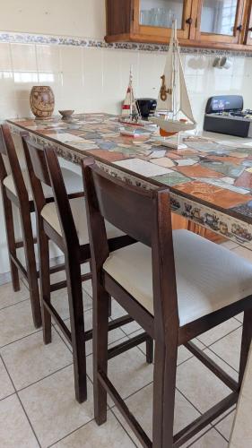 a wooden table with chairs and a table with a model boat on it at Apartamento Coco & Tambor in Livingston Izabal in Lívingston