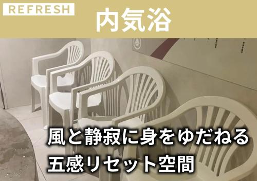 a sign with four white chairs in a room at スゴイサウナ アンド ステイ 麻布十番駅前 男性専用 in Tokyo
