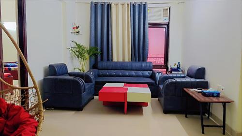 a living room with two blue couches and a table at AirNova 3BHK in Sonīpat